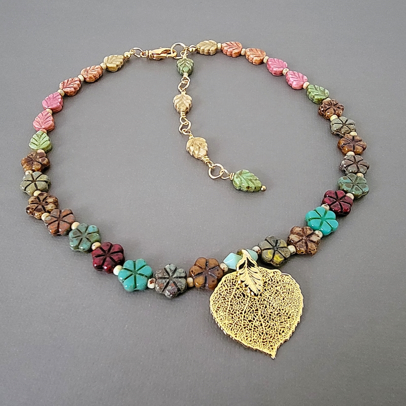 Multicolor Czech glass beaded choker, with adjustable extender chain. Flowers and leaves, with gold tone leaf pendant.